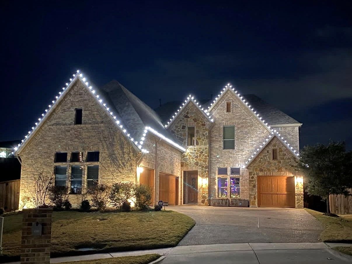 Two-story stone home with white roofline lighting
