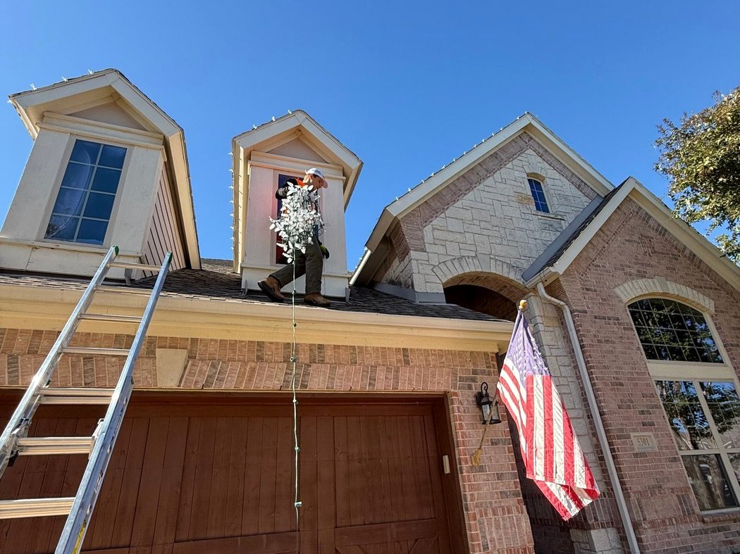 Bright's crew installing lights on a two-story home